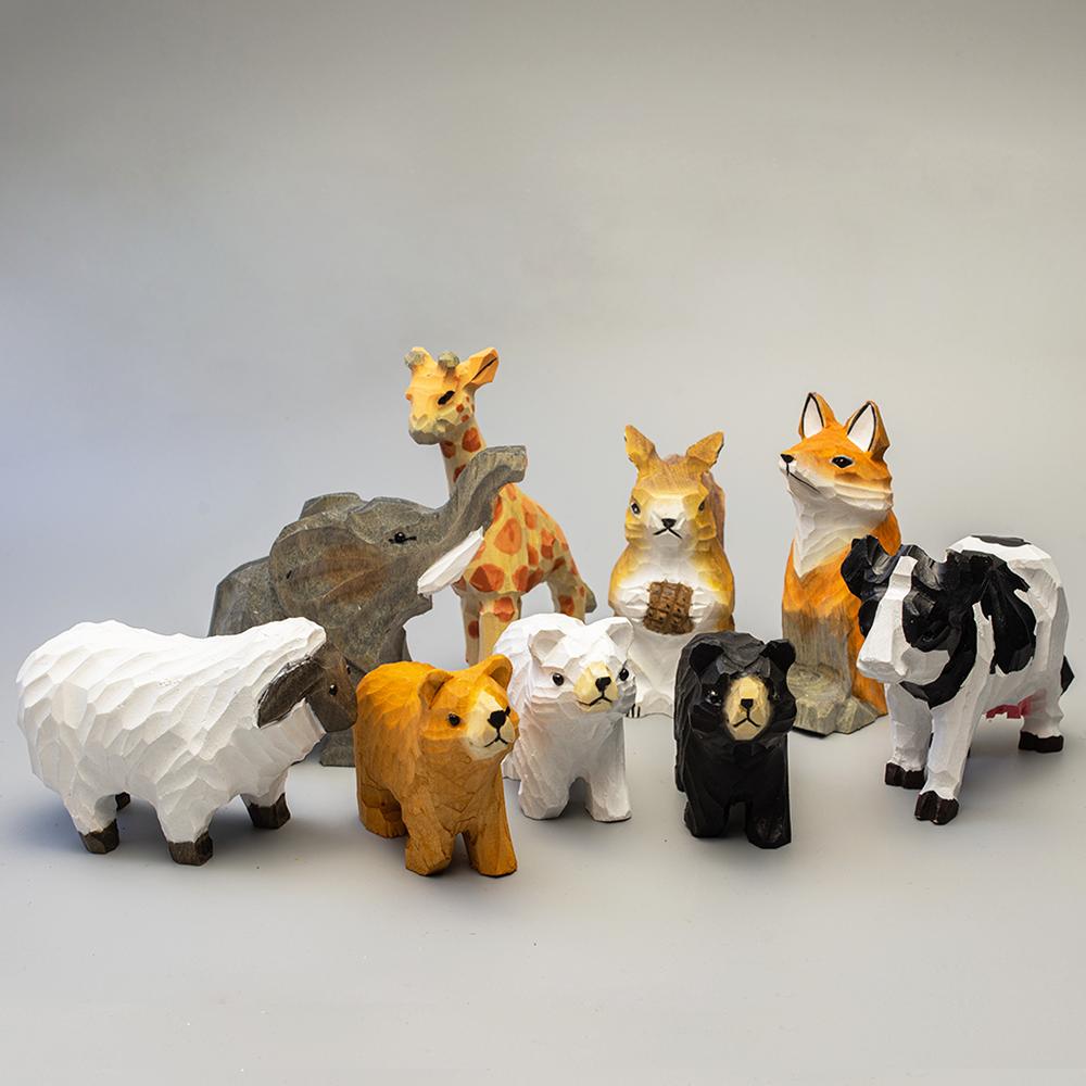 Barn & Beyond, a collection of hand-carved wooden animal figurines featuring sheep, bears, cows, foxes, and more.