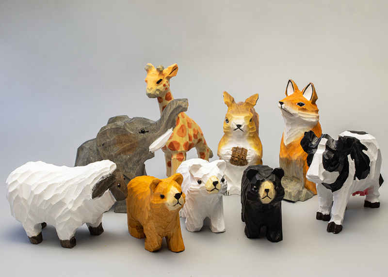 Barn & Beyond, a collection of hand-carved wooden animal figurines featuring sheep, bears, cows, foxes, and more.