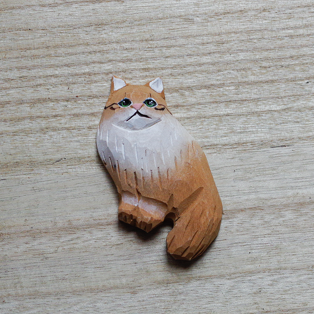 cat-shaped decorative magnets on a wooden surface