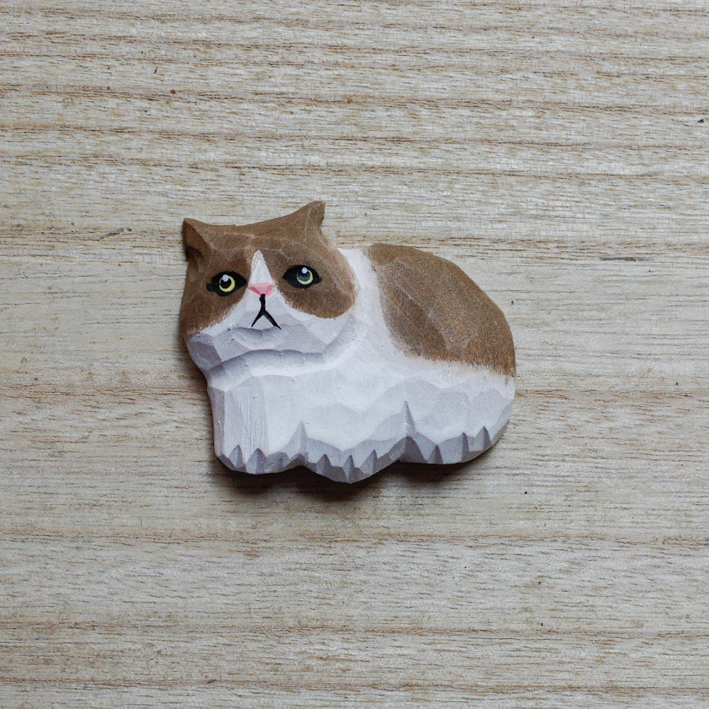 cat-shaped decorative magnets on a wooden surface