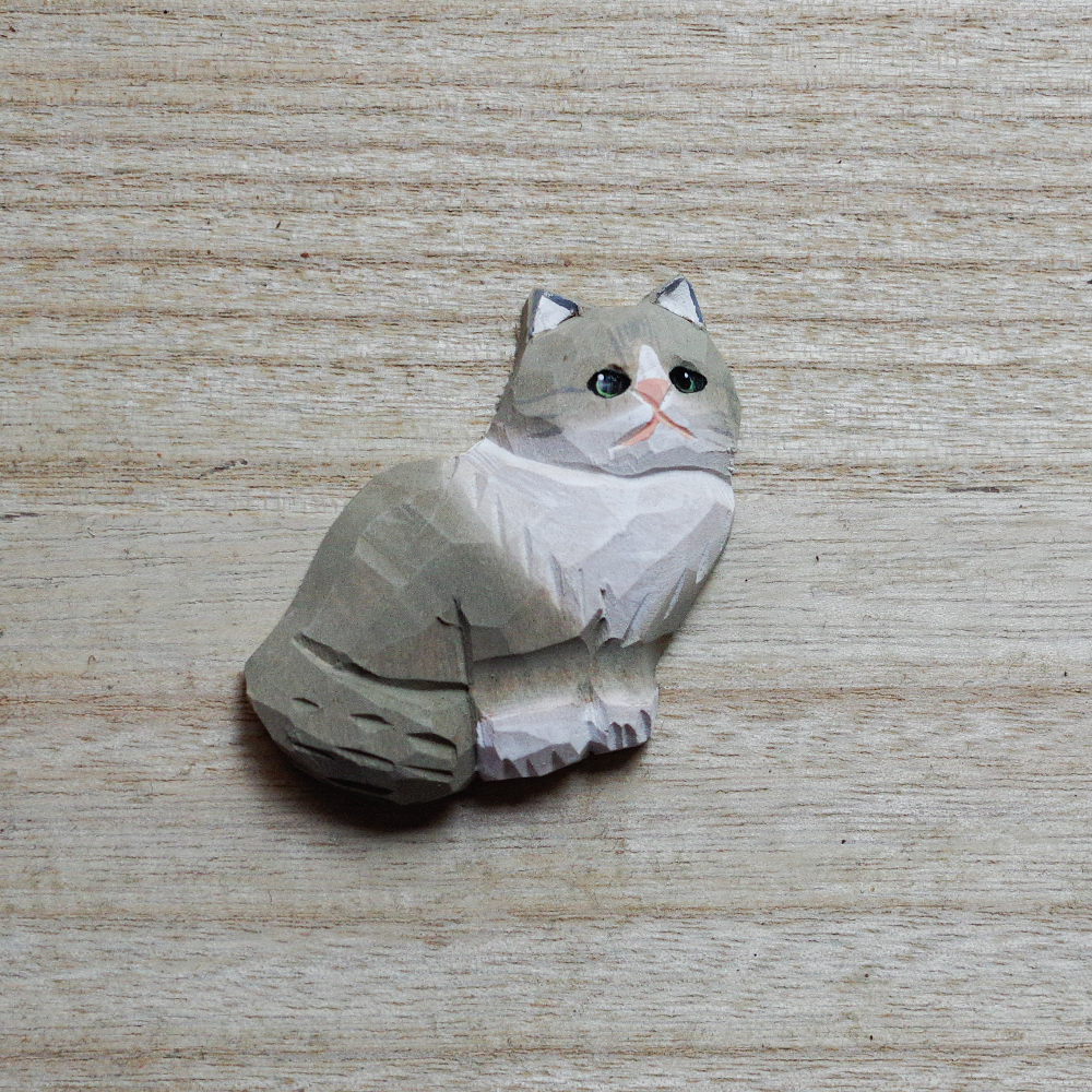 cat-shaped decorative magnets on a wooden surface