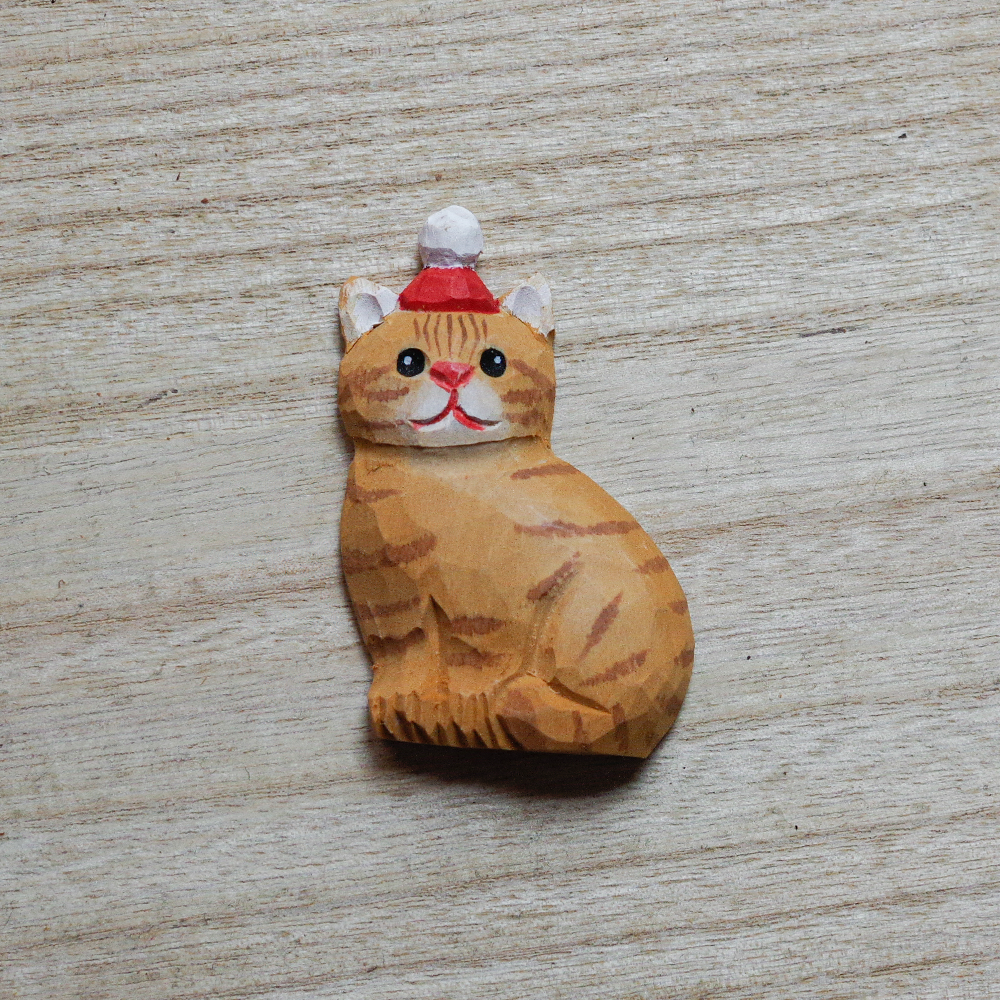 cat-shaped decorative magnets on a wooden surface