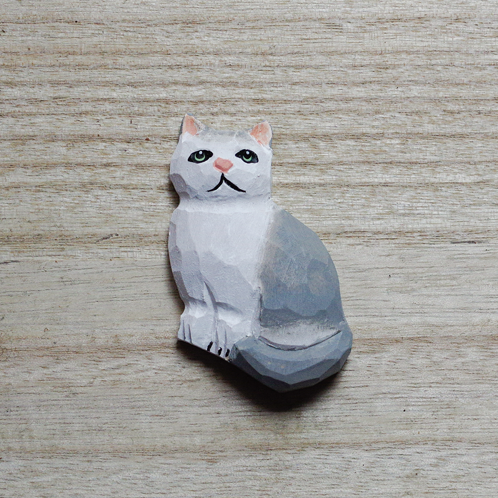 cat-shaped decorative magnets on a wooden surface