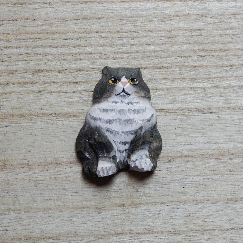 cat-shaped decorative magnets on a wooden surface