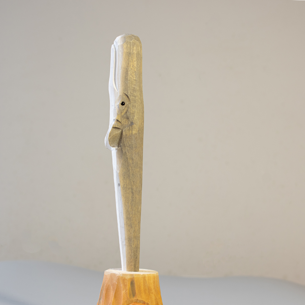 Wooden humpback whale pen with a handle on a light gray background