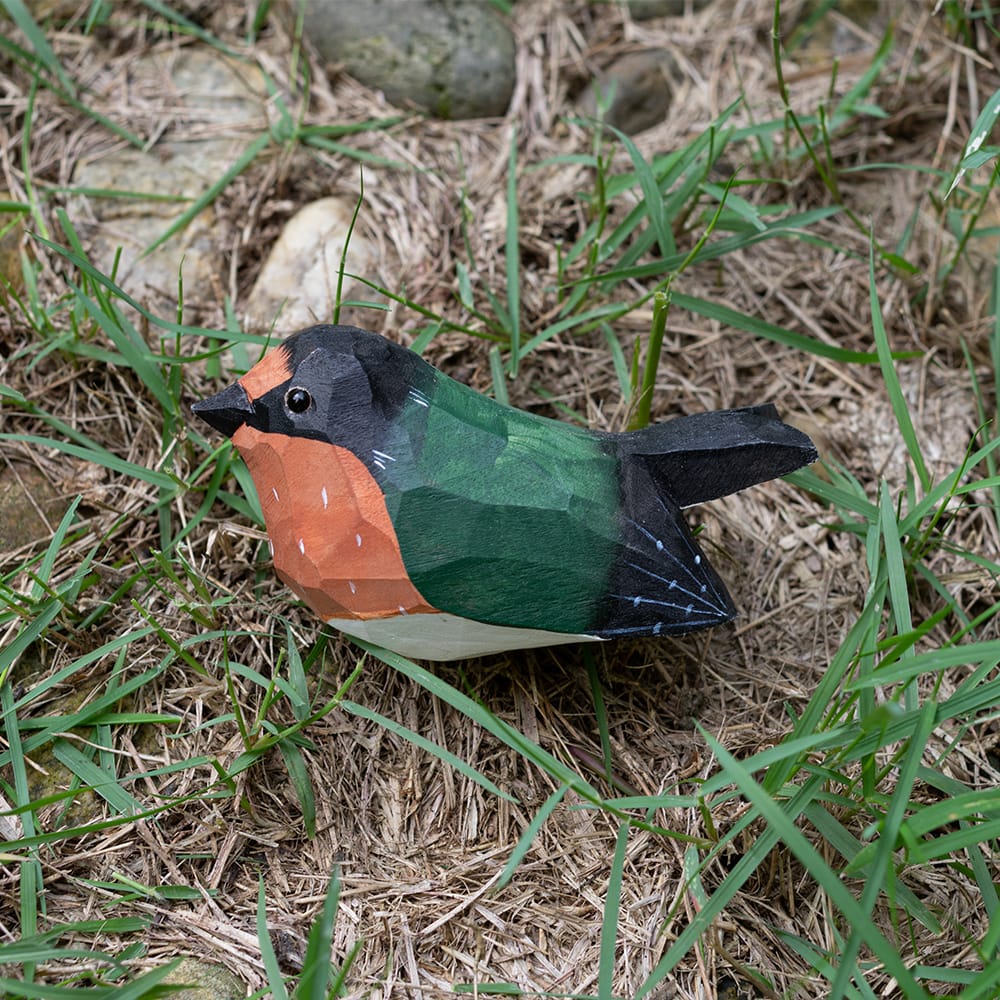 Colorful barn swallow wood figure on grass