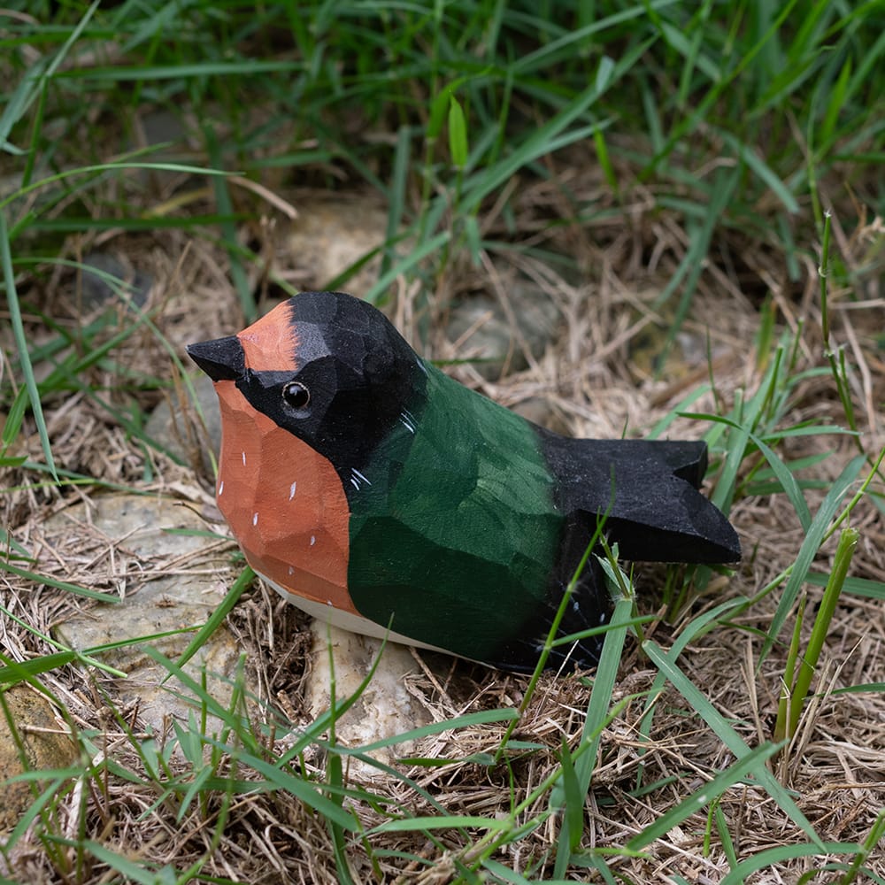 Colorful barn swallow wood figure on grass