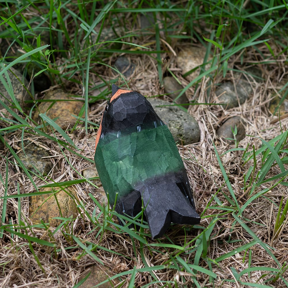 Colorful barn swallow wood figure on grass