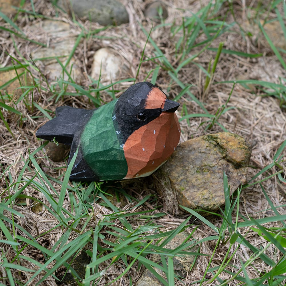 Colorful barn swallow wood figure on grass