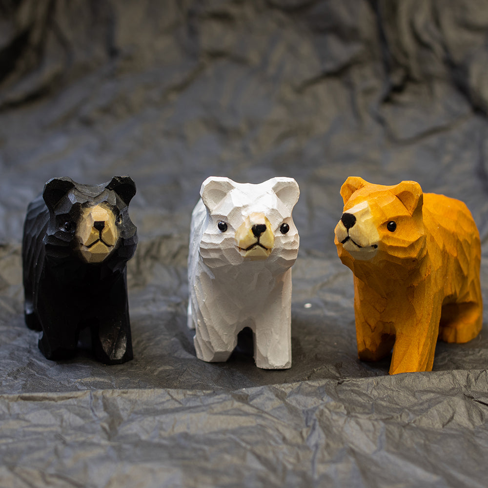 Hand-carved wooden figurines of a black bear, brown bear and polar bear. 