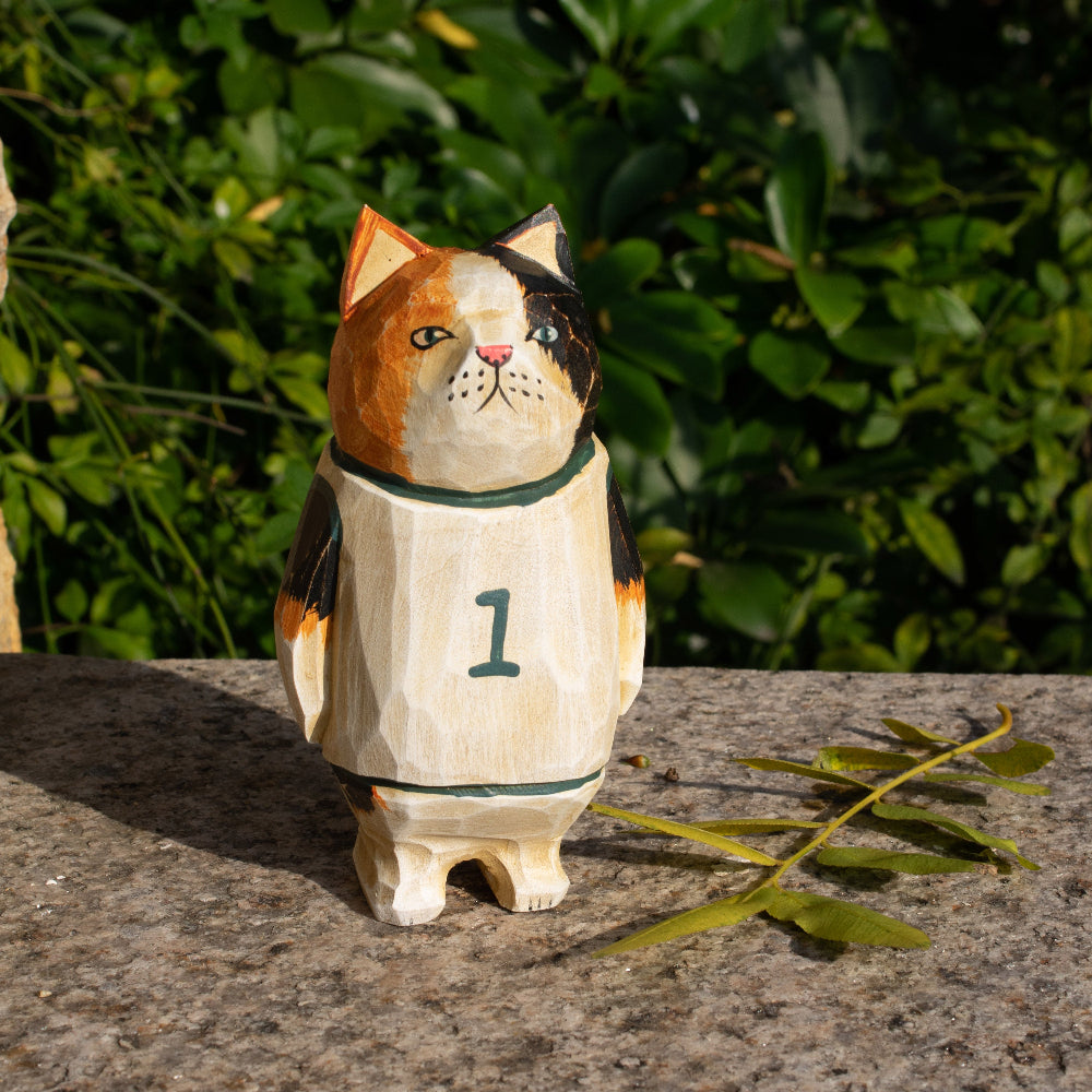 Hand-carved wooden figurine of a calico cat basketball player, ideal for sports fans and cat lovers.