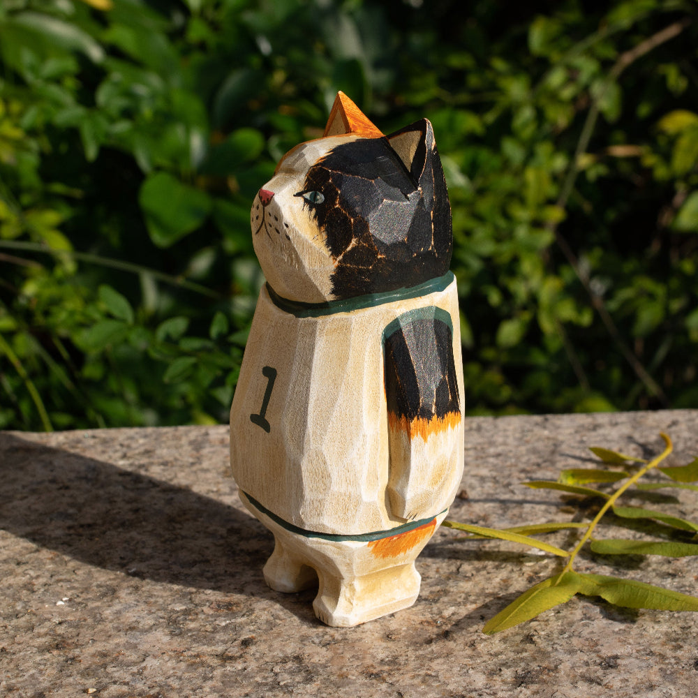 Hand-carved wooden figurine of a calico cat basketball player, ideal for sports fans and cat lovers.