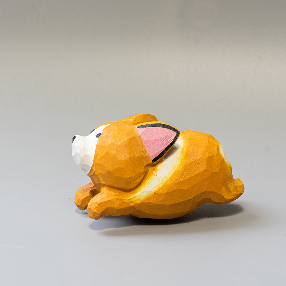 Hand-carved wooden Corgi figurine in a playful 'sploot' running pose. An energetic wood dog figure. 