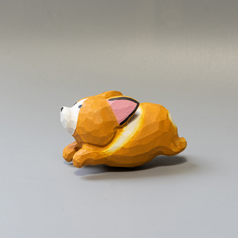 Hand-carved wooden Corgi figurine in a playful 'sploot' running pose. An energetic wood dog figure. 