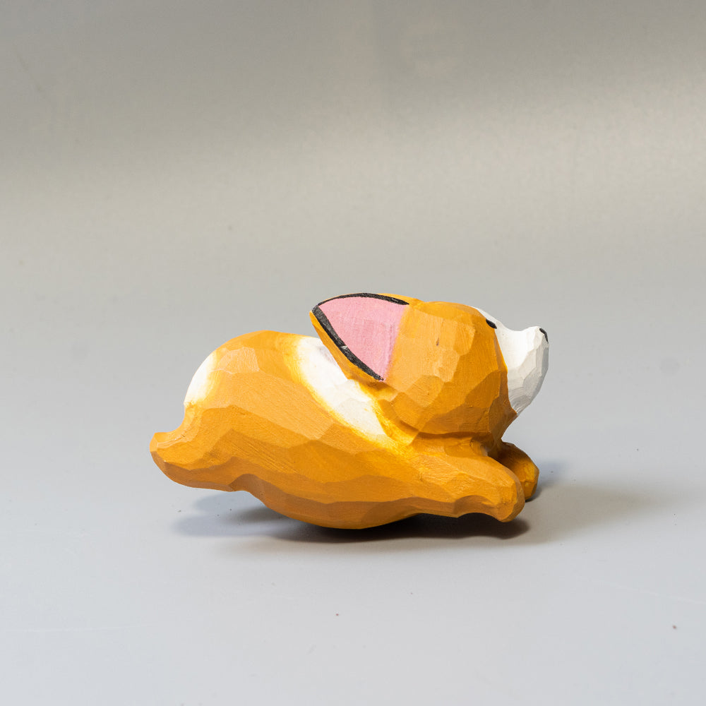 Hand-carved wooden Corgi figurine in a playful 'sploot' running pose. An energetic wood dog figure. 