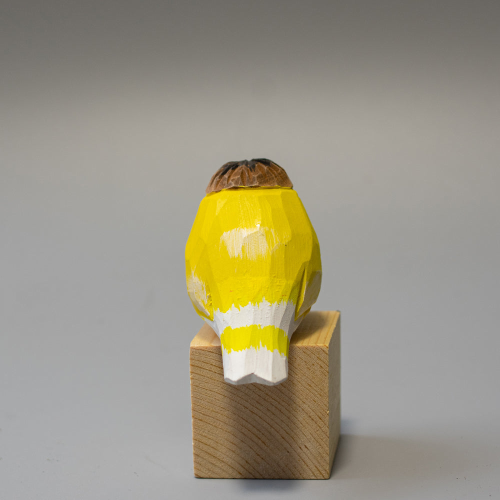 Hand-carved wooden Crested Canary figurine in bright yellow with a distinct feathered crest. 