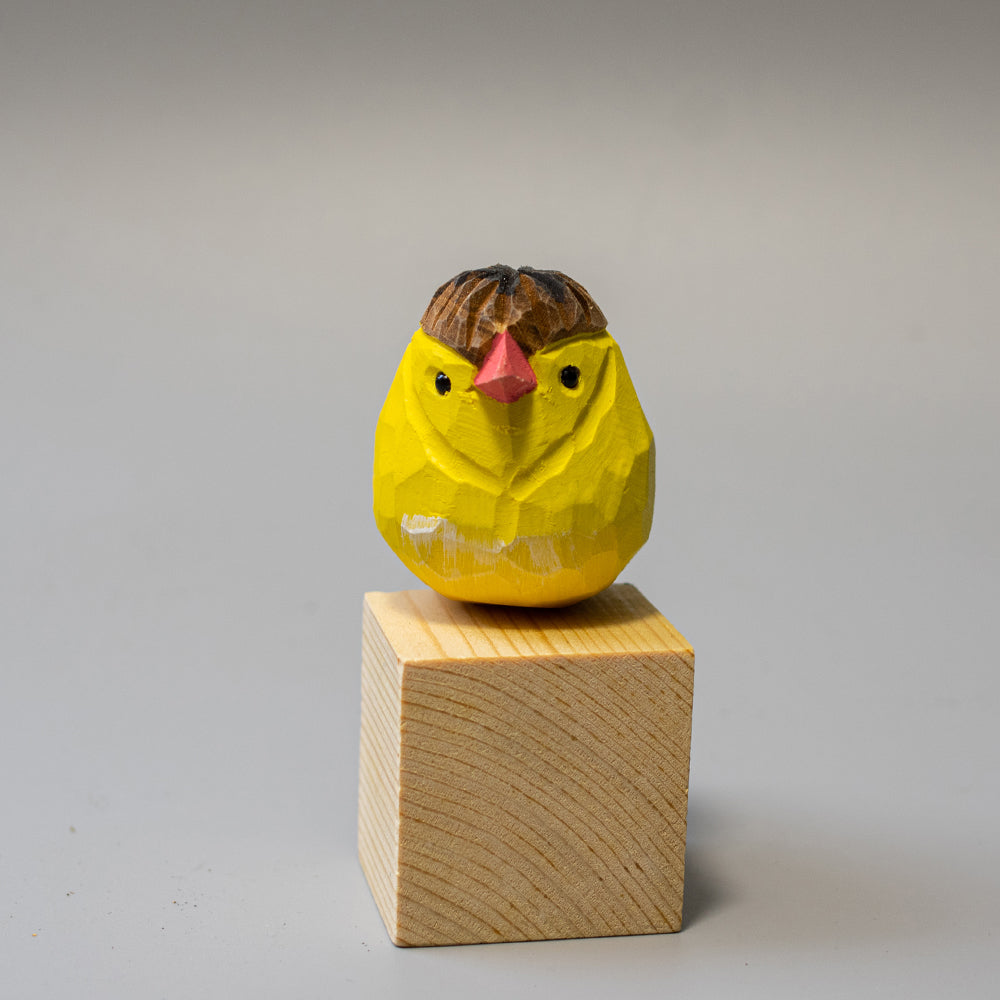 Hand-carved wooden Crested Canary figurine in bright yellow with a distinct feathered crest. 