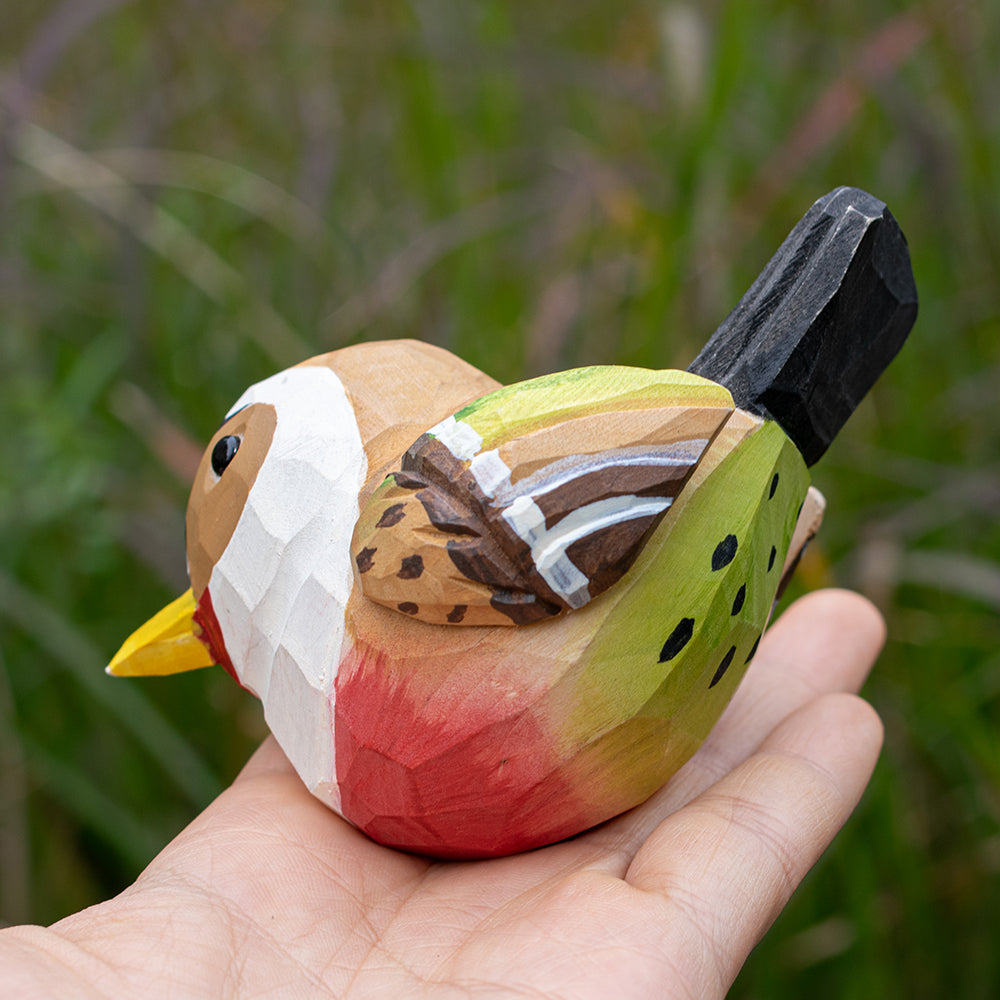 Detailed wooden goldfinch figurine with bright yellow and black coloring, hand-carved for unique decor.