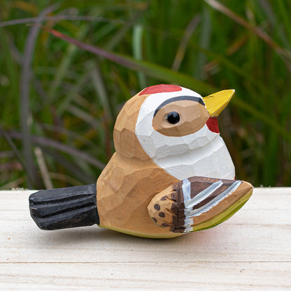 Detailed wooden goldfinch figurine with bright yellow and black coloring, hand-carved for unique decor.