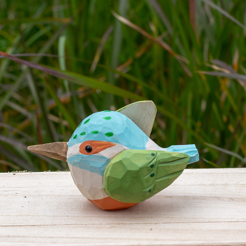 Hand-carved wooden kingfisher bird figurine with vibrant blue and green details from the Odd Flocks collection.