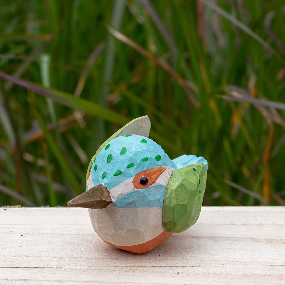 Hand-carved wooden kingfisher bird figurine with vibrant blue and green details from the Odd Flocks collection.