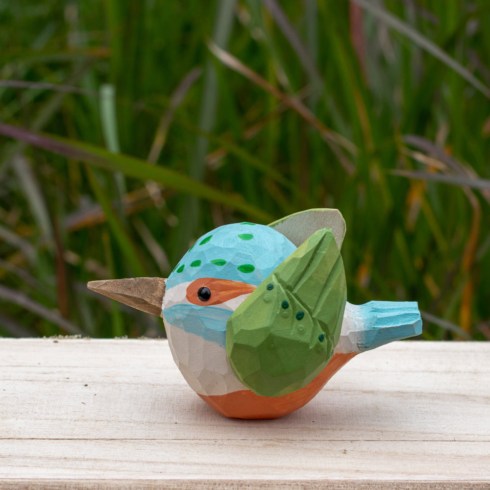 Hand-carved wooden kingfisher bird figurine with vibrant blue and green details from the Odd Flocks collection.