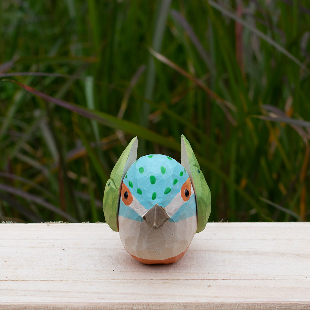 Hand-carved wooden kingfisher bird figurine with vibrant blue and green details from the Odd Flocks collection.