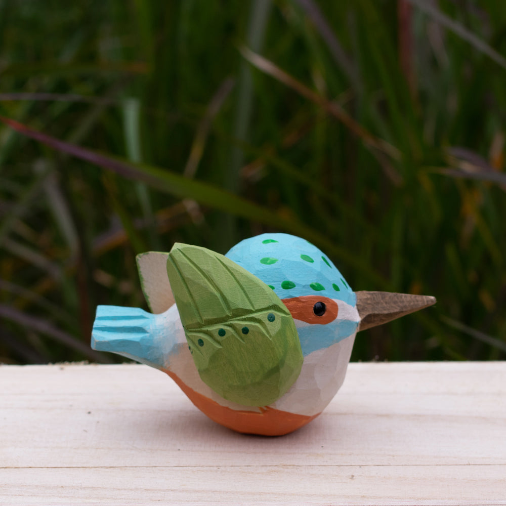 Hand-carved wooden kingfisher bird figurine with vibrant blue and green details from the Odd Flocks collection.