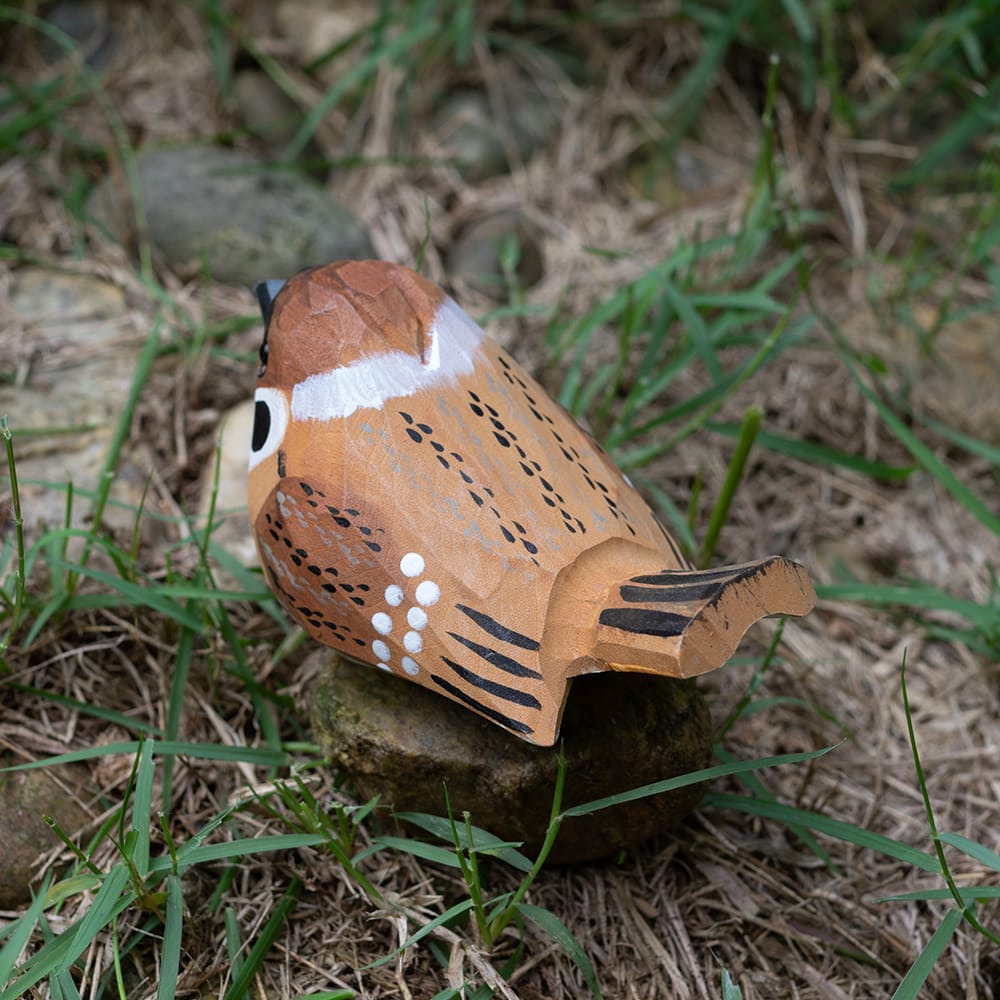 Wooden Eurasian Tree Sparrow figurine on a natural background