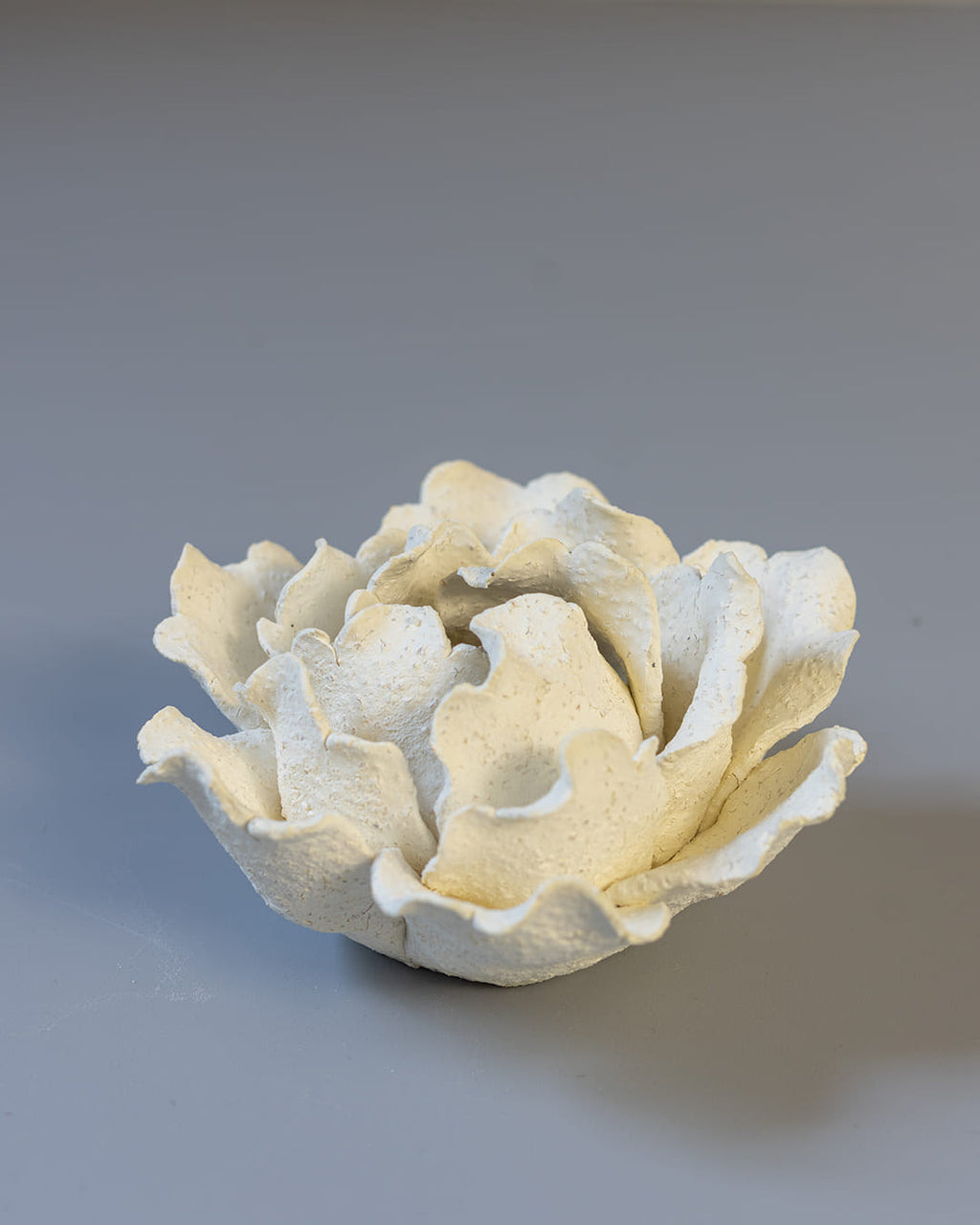 White ceramic incense holder on a white surface.
