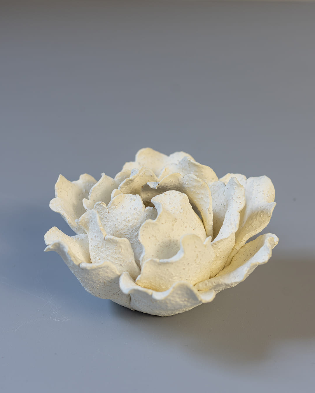 White ceramic incense holder on a white surface.
