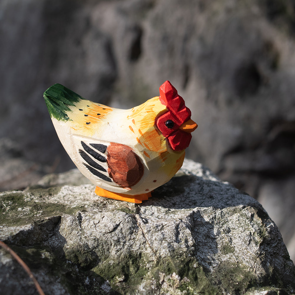 A hand-carved wooden figurines of a  barnyard hen. 