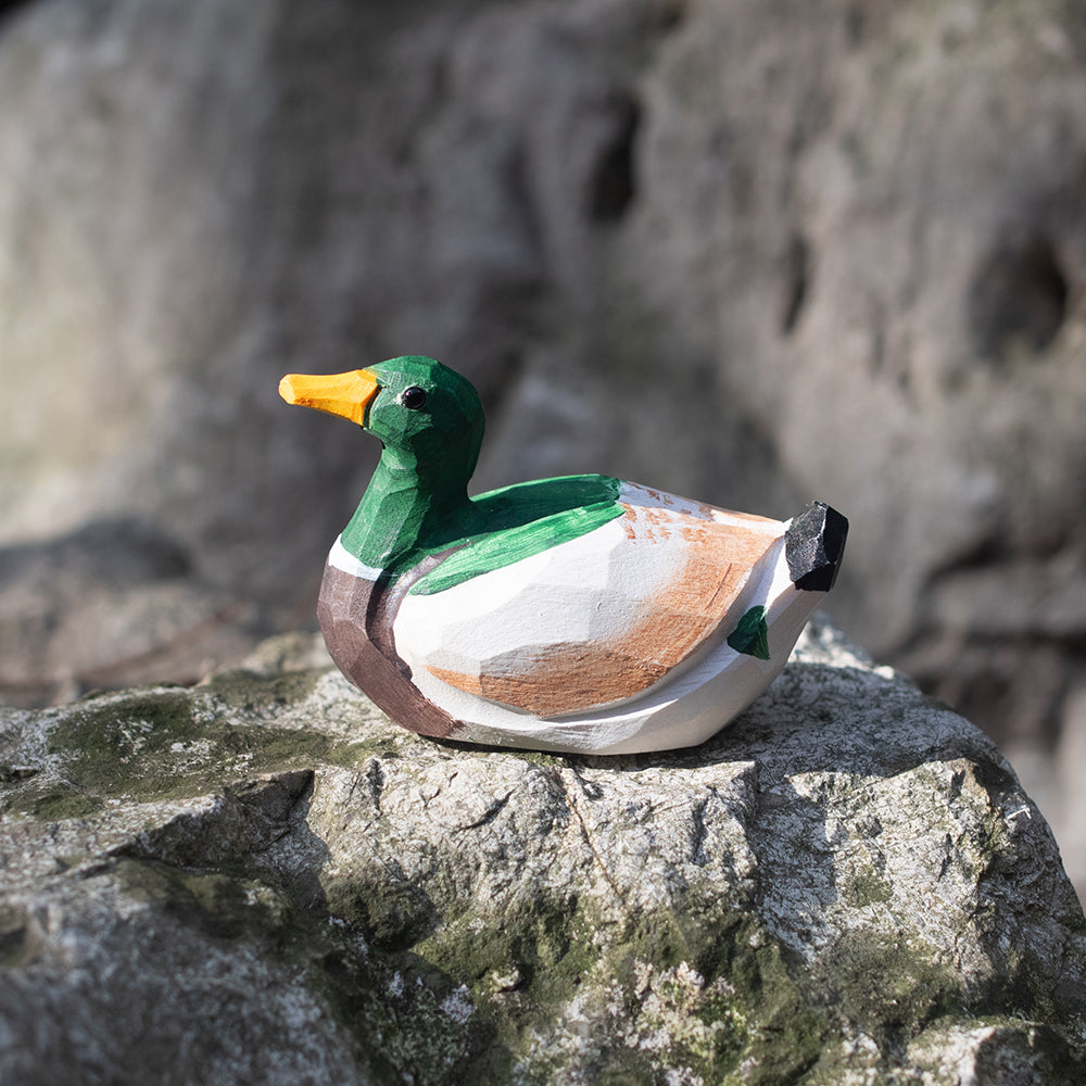 A hand-carved wooden figurines of a  mallard duck. 