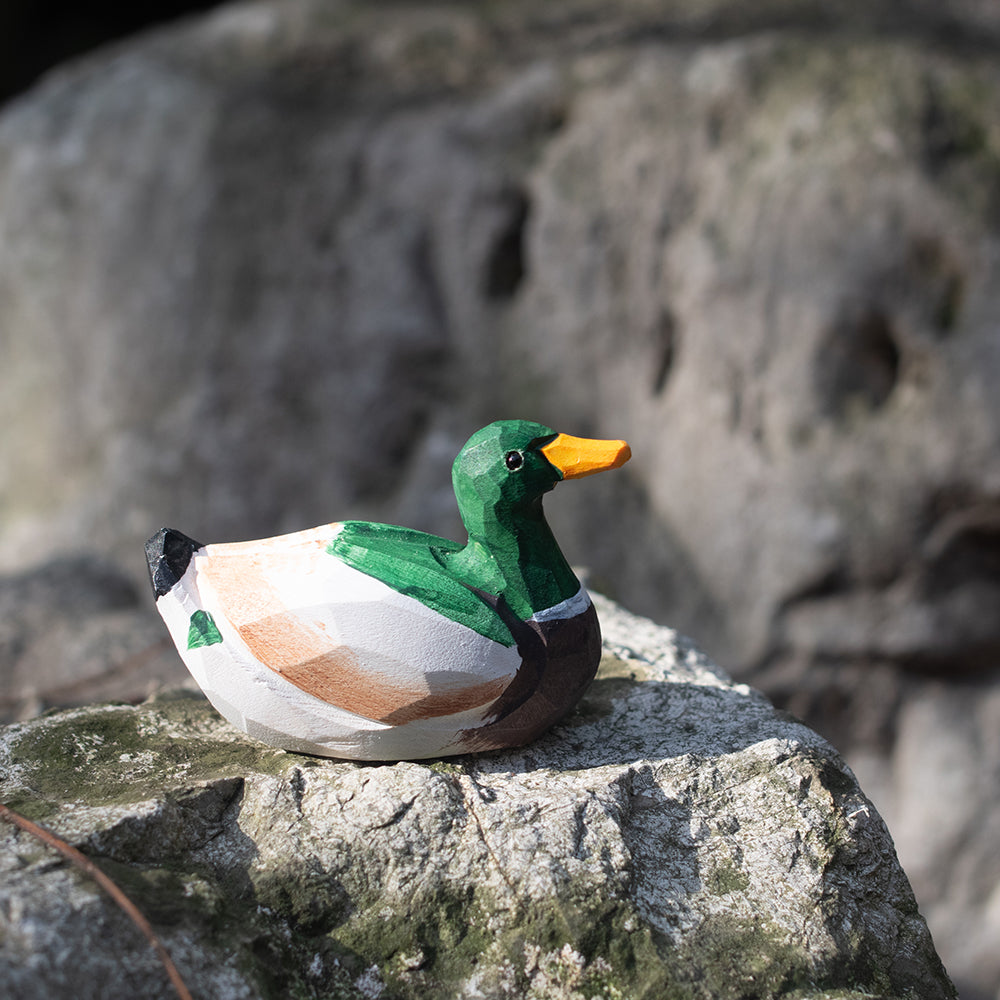 A hand-carved wooden figurines of a  mallard duck. 