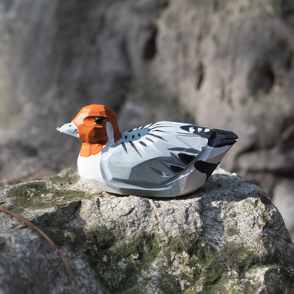 A hand-carved wooden figurines of a  rustic duck. 