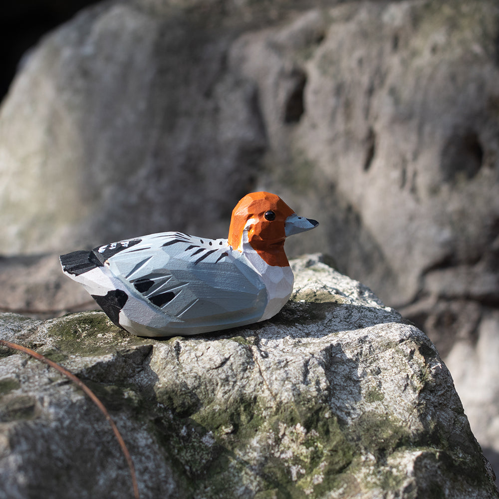A hand-carved wooden figurines of a  rustic duck. 