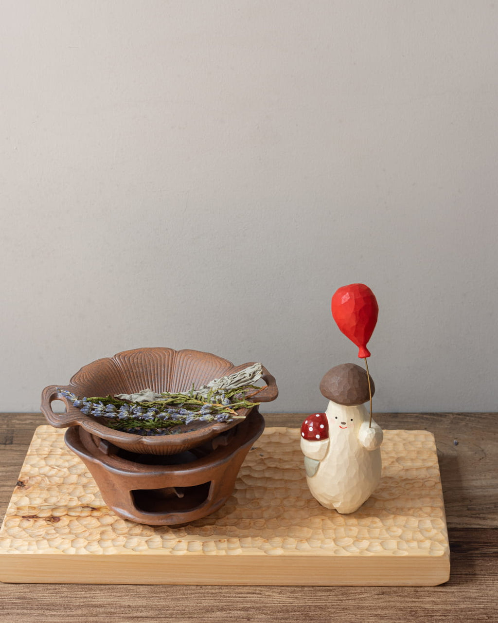 A rustic, two-piece ceramic aromatic warmer made from dark Aged Ore Clay, with a lotus-leaf-shaped dish resting on the stove base.