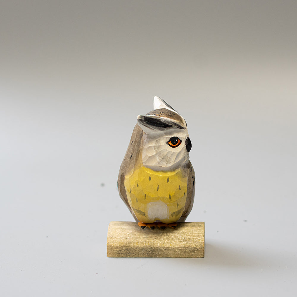 Hand carved wooden Northern White Faced Owl figurine with white facial disk and ear tufts, on a wood base. 