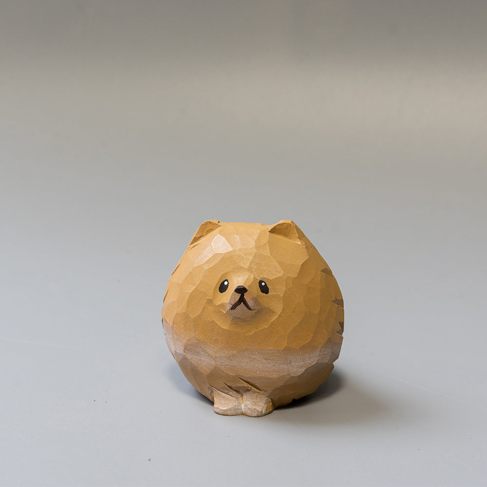 Wooden Pomeranian figurine on a gray background
