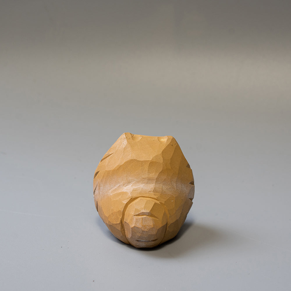 Wooden Pomeranian sculpture on a gray background