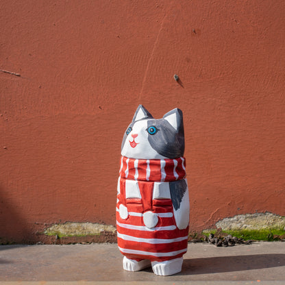 Hand-carved wooden cat figurine with a red-and-white striped scarf. Christmas-themed wood figurine, detailed wood carving, high-quality wooden figurines.