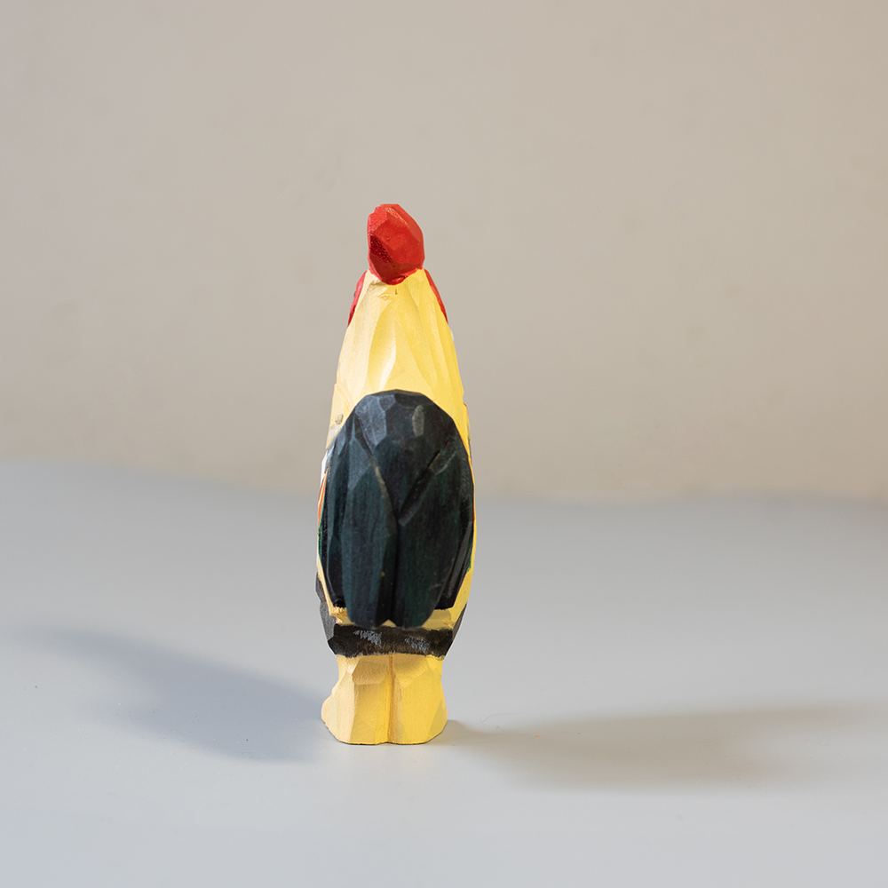 a rooster wooden figurine on a neutral background