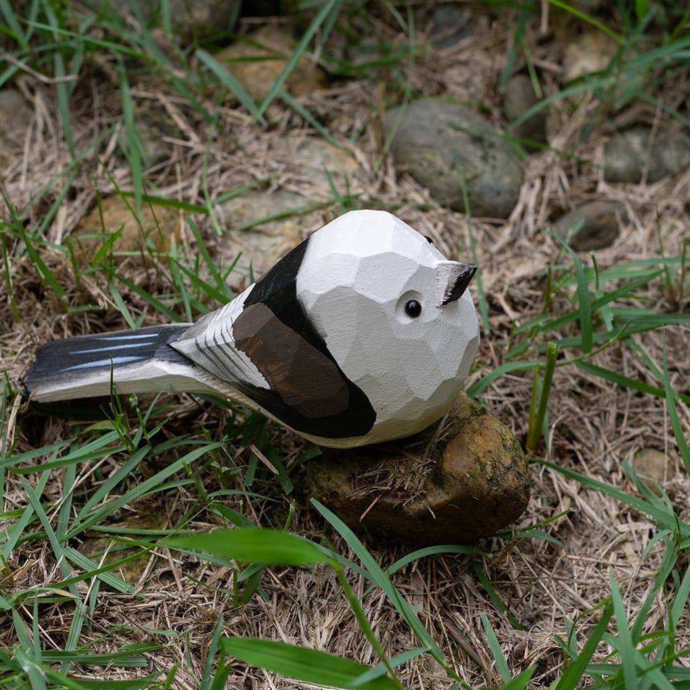 Wooden shima enaga figurine on grass