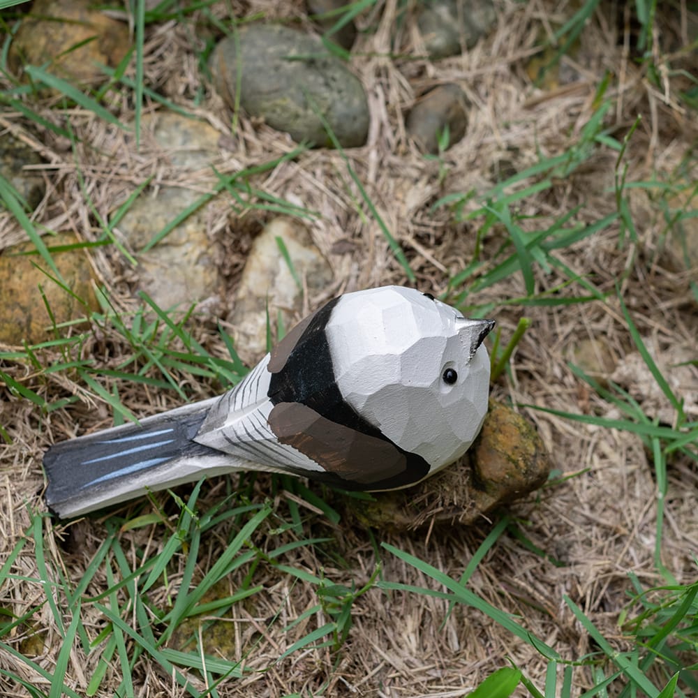 Wooden shima enaga figurine on grass
