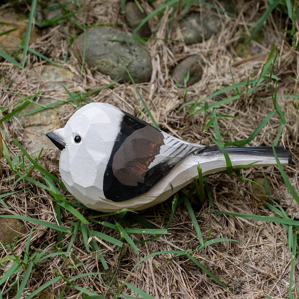 Wooden shima enaga figurine on grass