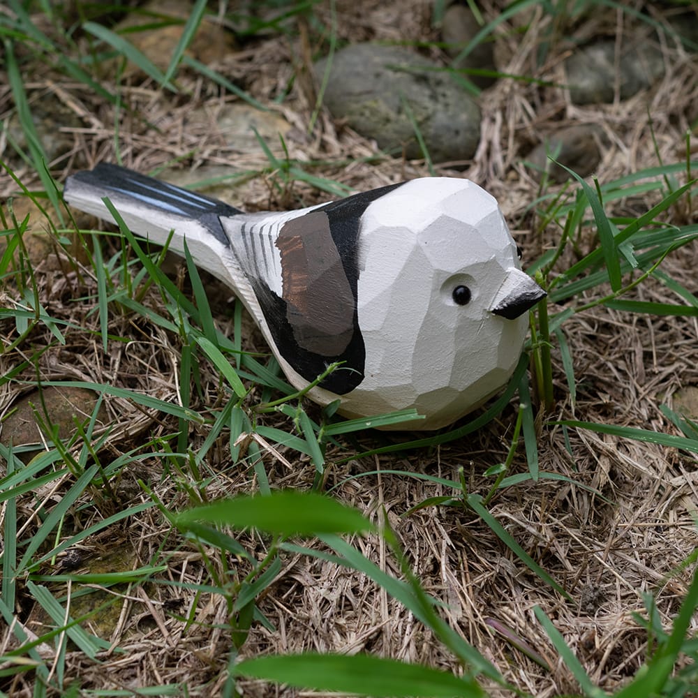 Wooden shima enaga figurine on grass