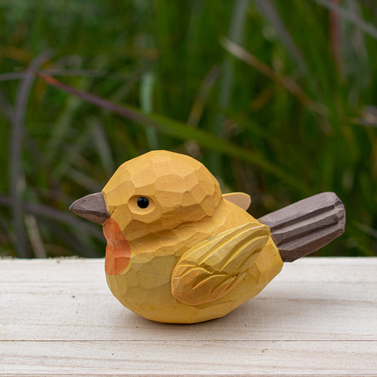 Handcrafted wooden warbler bird figurine in warm golden hues, part of the Odd Flocks collection.