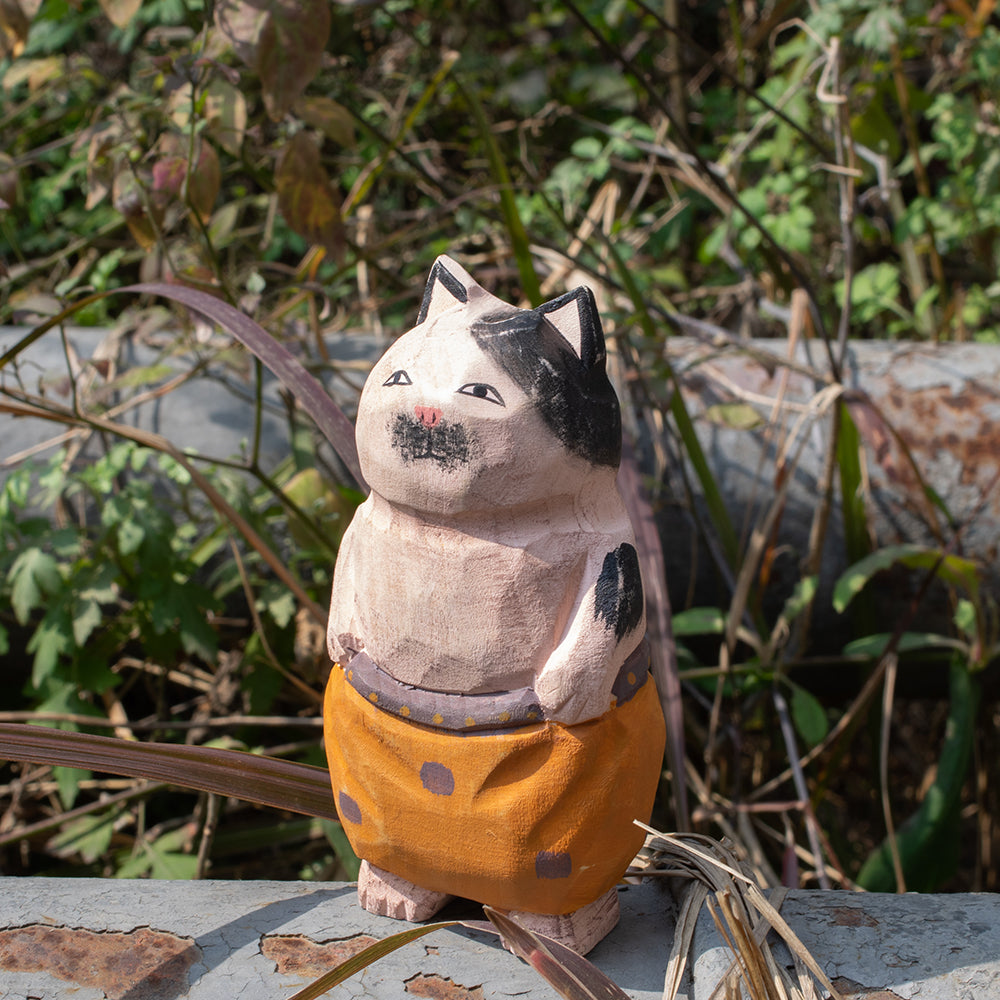 Hand carved wood figurine of a nomadic cat in patterned trousers. Unique carved wood figure, traditional wood art, detailed wooden figurine, high quality wood carving.