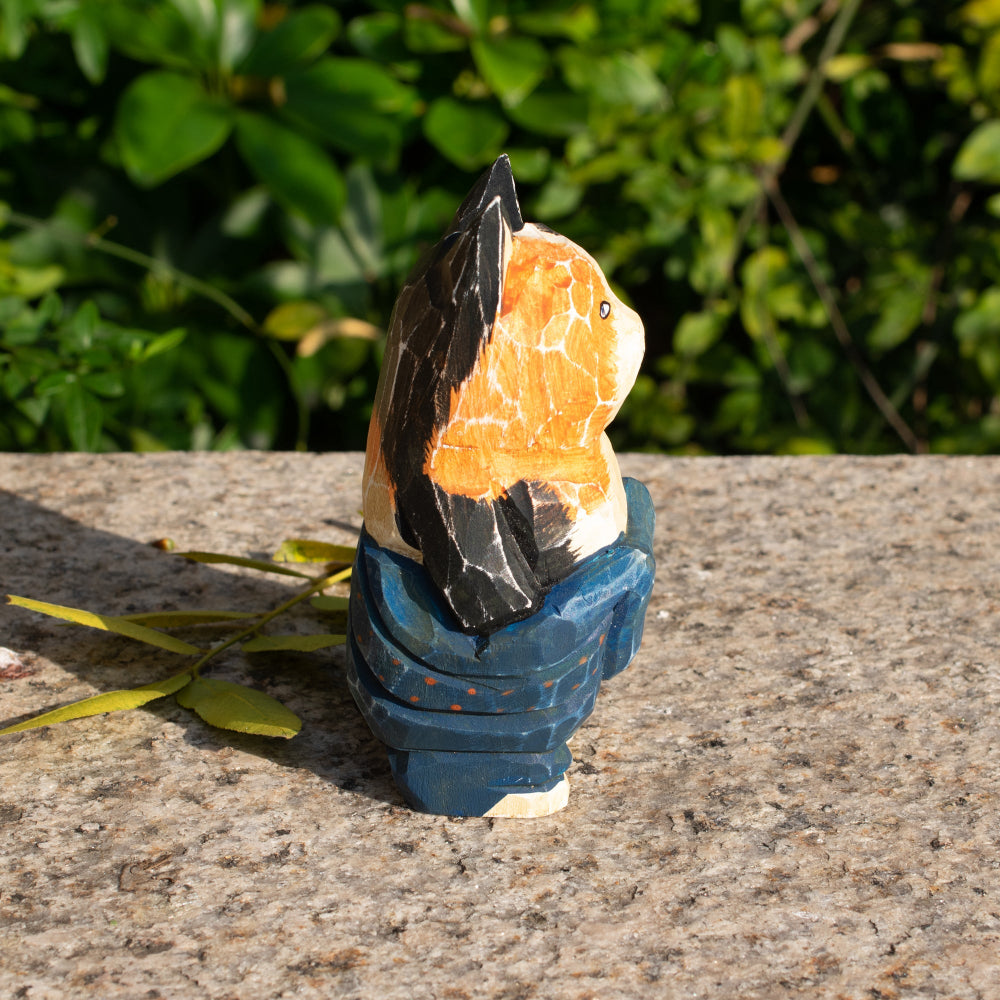 Hand-carved wooden figurine of a lounging calico cat in overalls, a playful addition to cat lover decor.