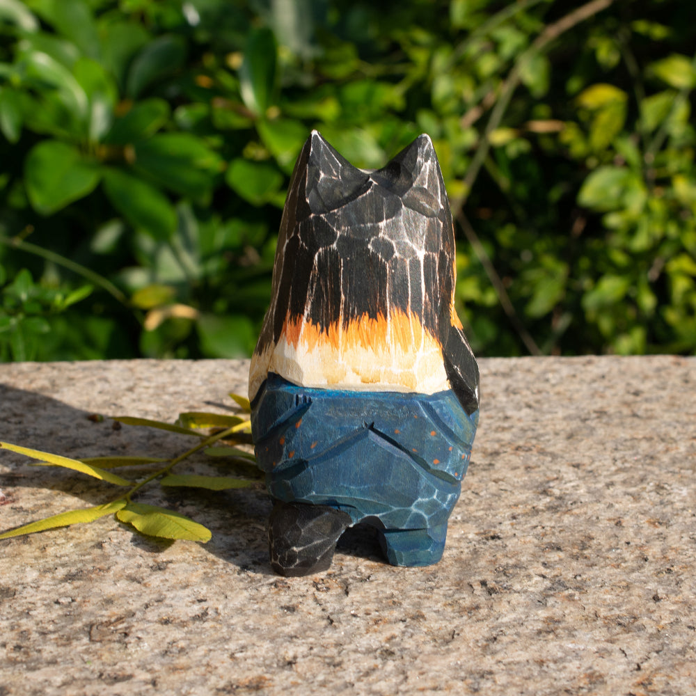 Hand-carved wooden figurine of a lounging calico cat in overalls, a playful addition to cat lover decor.